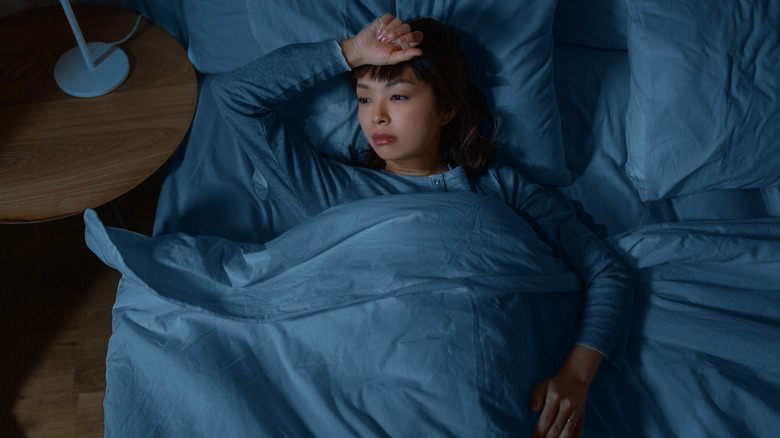 Young woman laying awake in bed