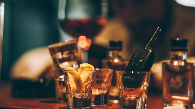 empty shot glasses with alcohol bottles and wine glass