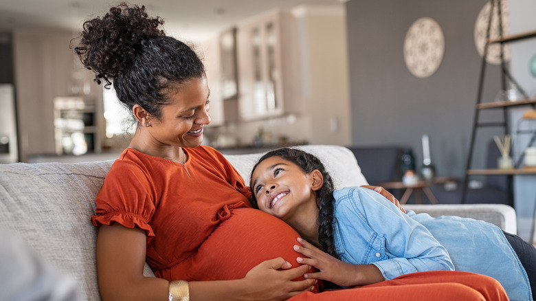 pregnant woman and daughter smiling