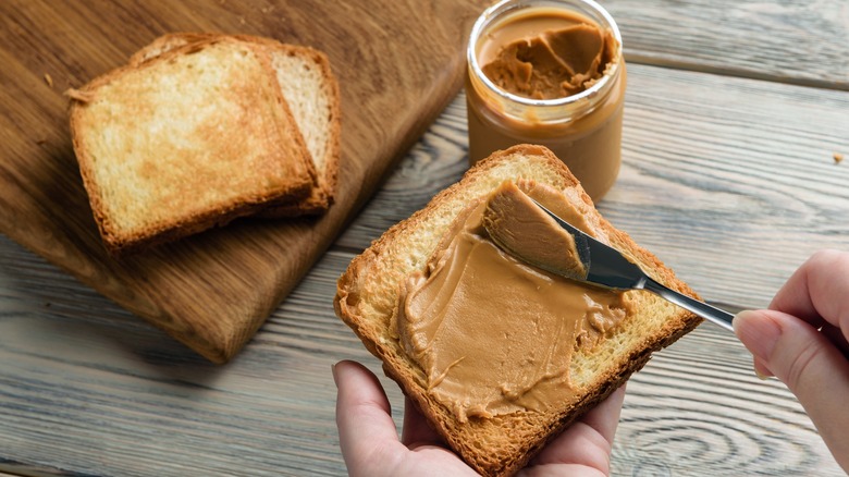 spreading peanut butter on bread