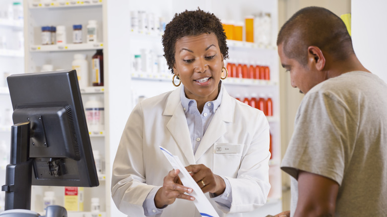 Man picking up prescription at pharmacy