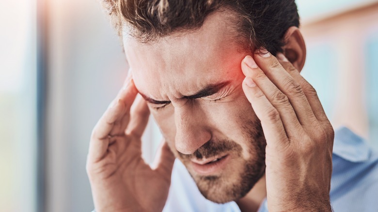 man holding his temples with a headache