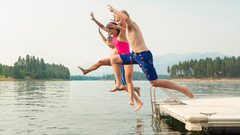Teenagers jumping into lake