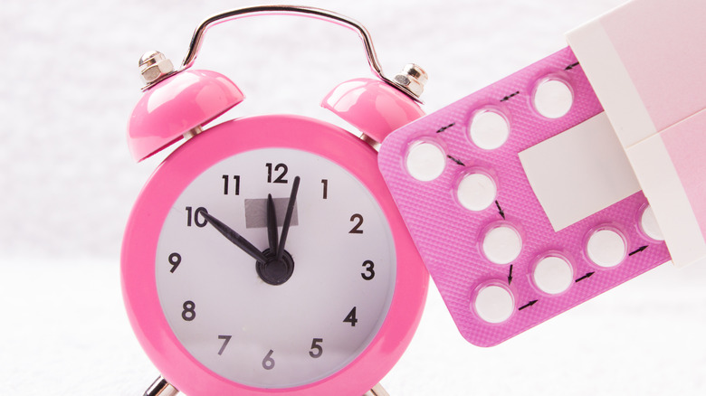 Pink alarm clock and pills