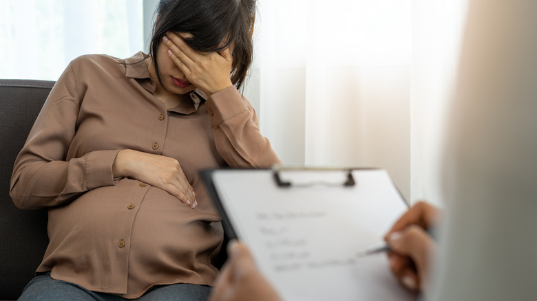 Pregnant woman covering eyes