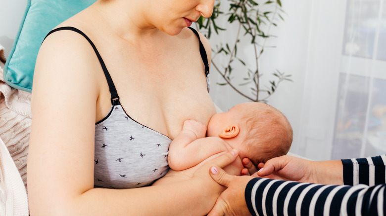 Lactation consultant helps baby latch onto mother