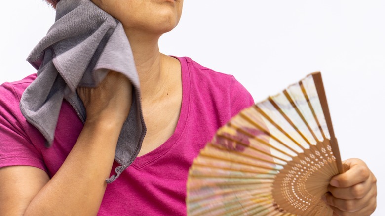 woman perspiring and fanning self