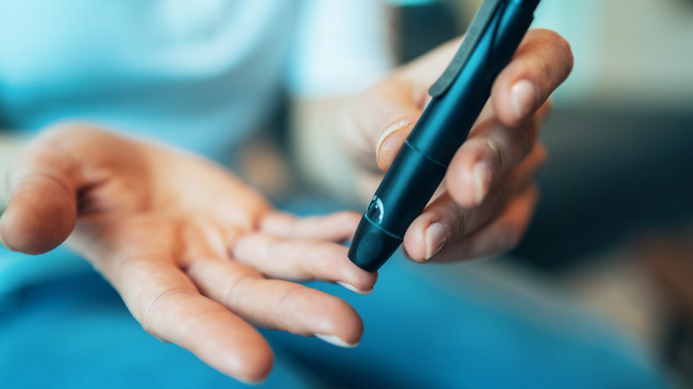 Person self-administering a blood sugar test