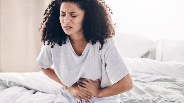 Woman on bed with stomach pain