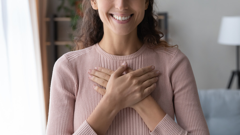 Woman holding heart and smiling