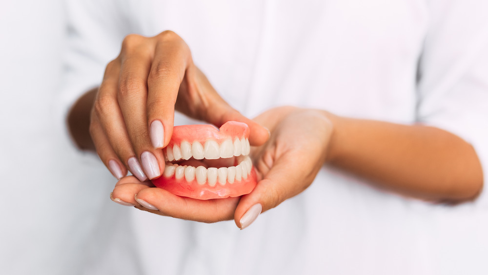 person holding dentures