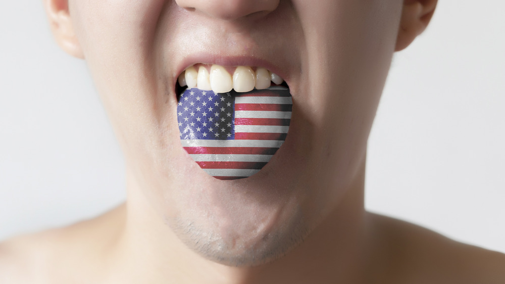 man sticks out tongue with U.S. flag