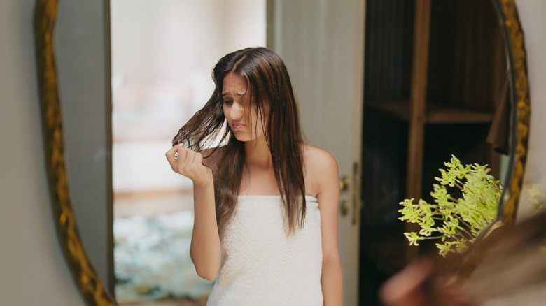 woman in mirror unhappy about hair