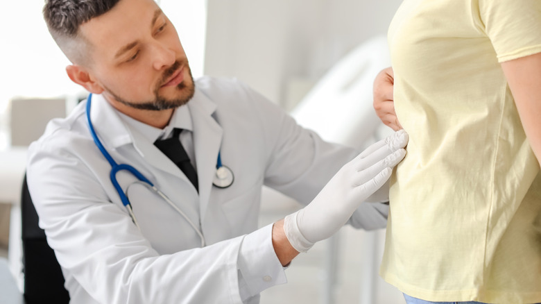 Doctor examining man's abdomen