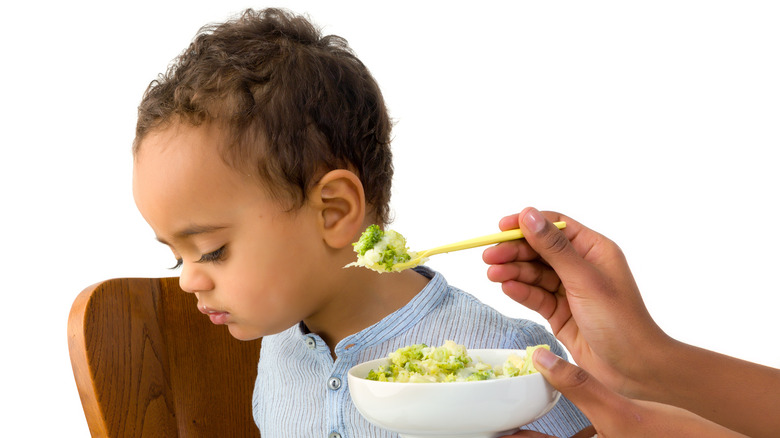 A baby refusing a spoonful of food