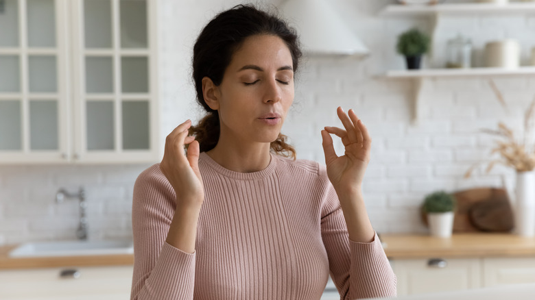 a woman practices breathing to relieve stress