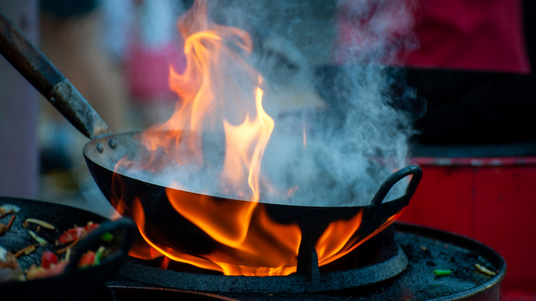 wok with smoke and flame in it