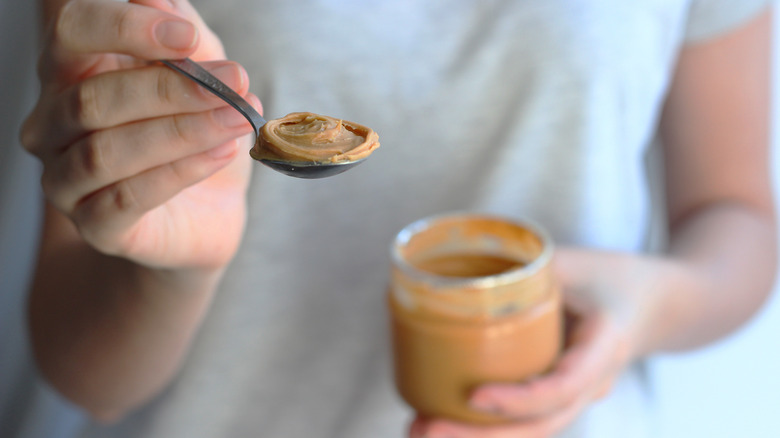 hand holding spoonful of peanut butter