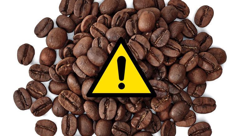 Roasted coffee beans with a warning sign 