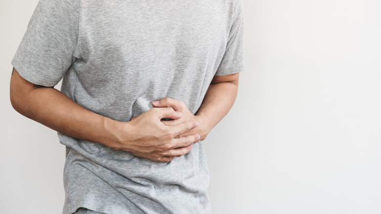 man holding abdomen from pain