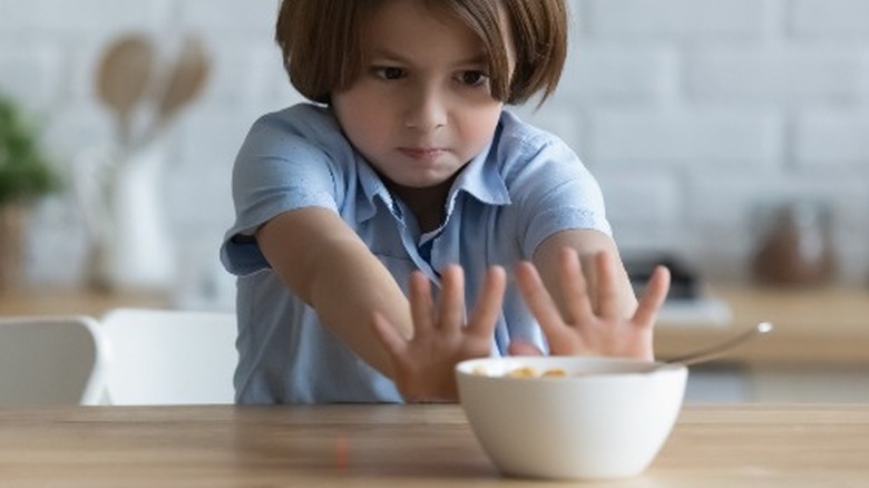 Young boy pushing food away