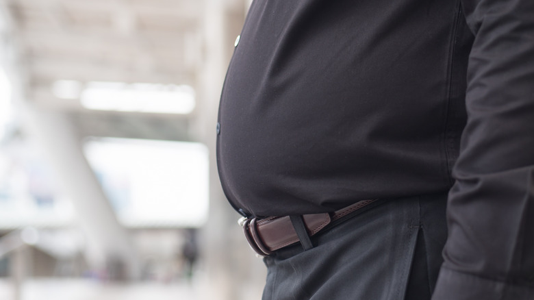 Close up of man's belly bulging over his beltline