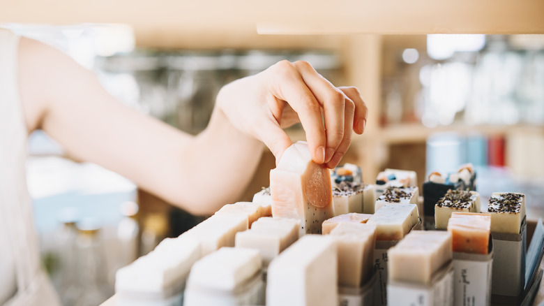 Hand picking up soap from shelf