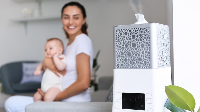 Mother with baby breathing from humidifier 