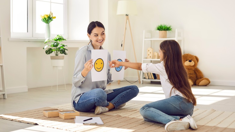 a child chooses between happy and sad face 