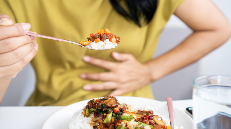 Women holding her stomach when eating