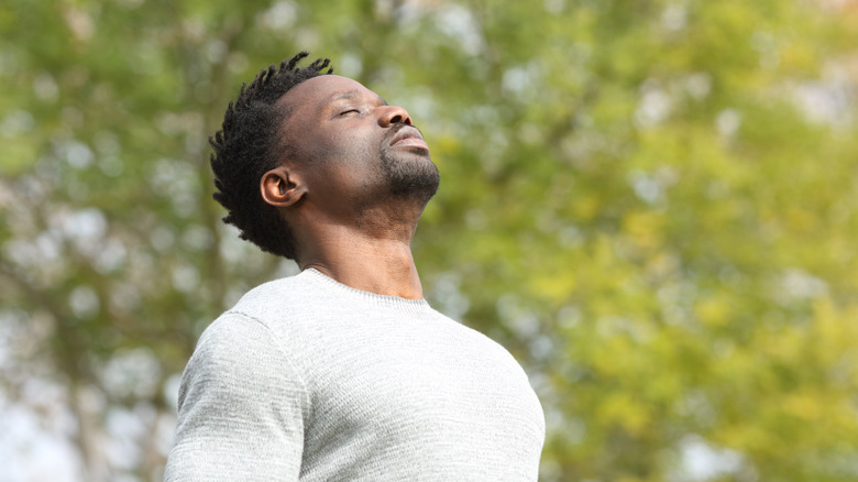 man breathing in fresh air outdoors