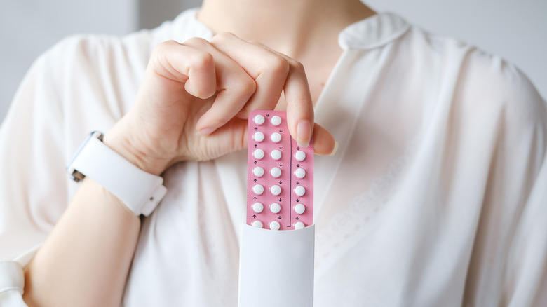 woman holding oral contraceptives