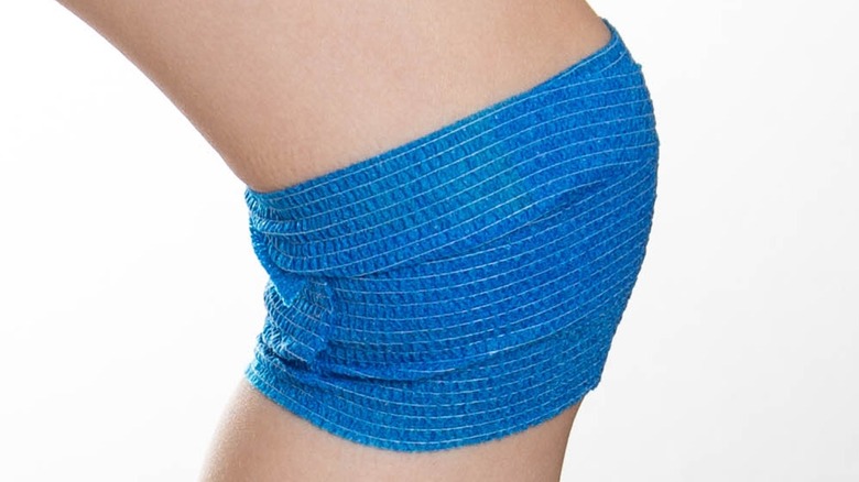 close-up of knee with blue wrap tape