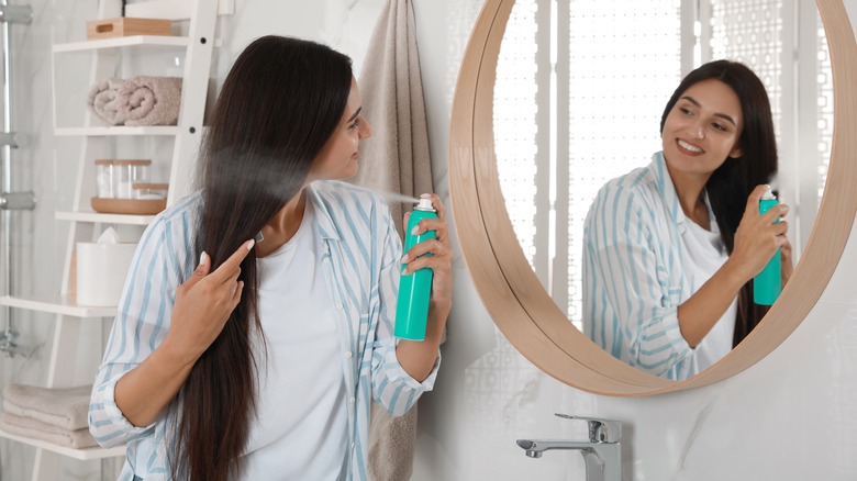 woman putting on dry shampoo