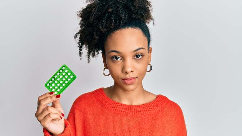 woman holding birth control pills