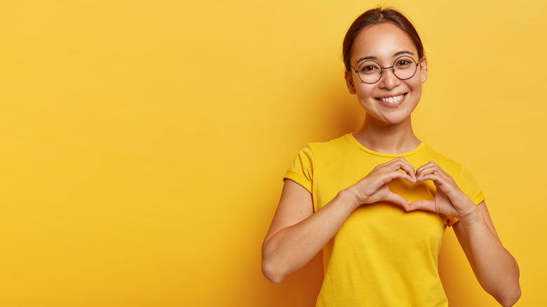 woman holding hands over heart