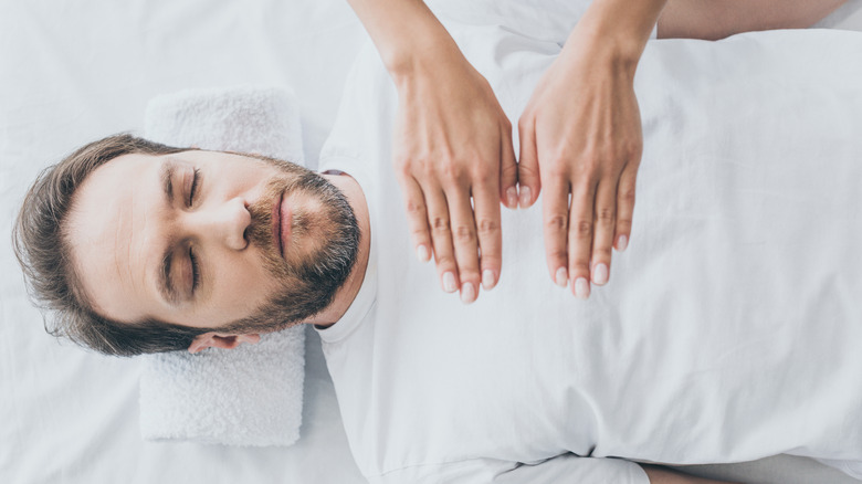 man receiving reiki treatment