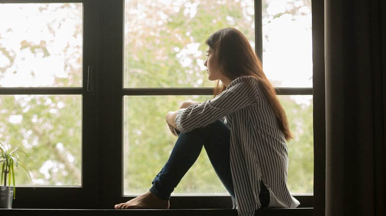 Woman alone looking out window