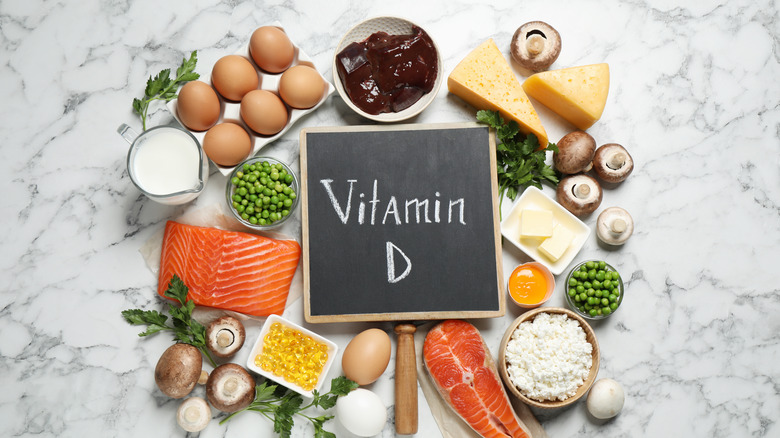Vitamin D sign surrounded by vitamin D-rich food on table