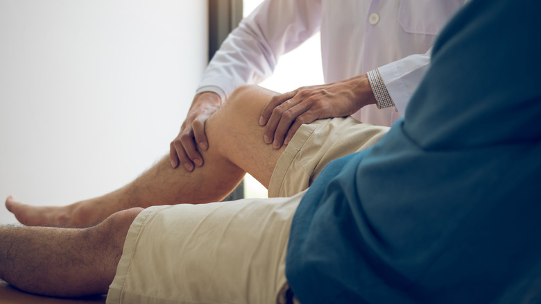 Doctor checking patient's knee