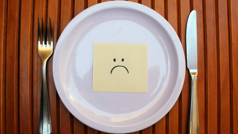 Empty plate with a sad face drawing