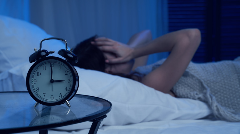 tired woman with insomnia lying on bed