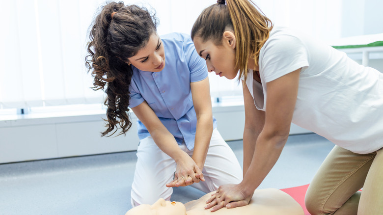 Two people administering CPR