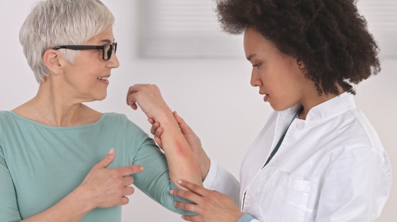 dermatologist examines patient's arm
