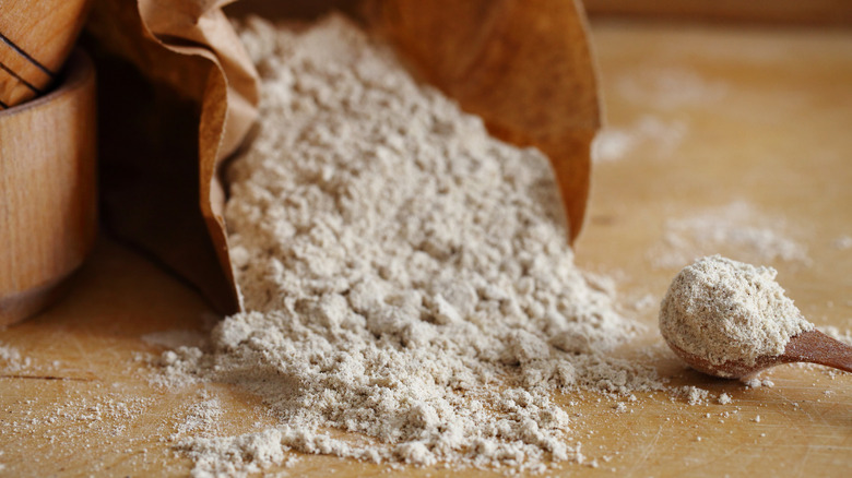 package of whole grain flour tipped onto table