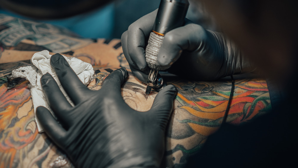 Close up of a tattoo artist applying a large tattoo