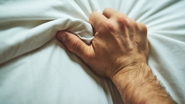 Man squeezing bedsheet