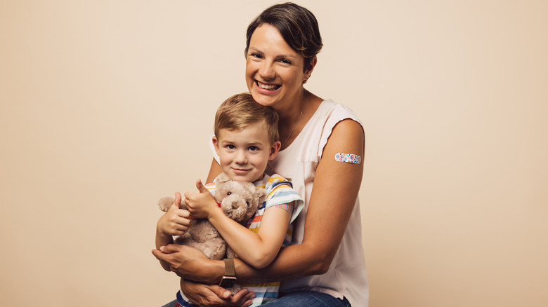 mother and son with vaccine band-aids on arm