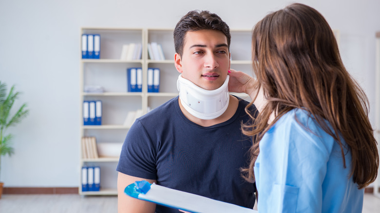 Man wearing neck brace with doctor