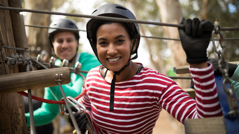 Man and woman zip lining smiling